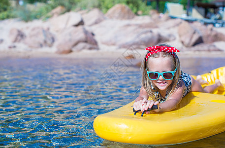 可爱的小女孩喜欢在清清楚楚的水中 在黄皮艇上游泳 海洋 享受图片