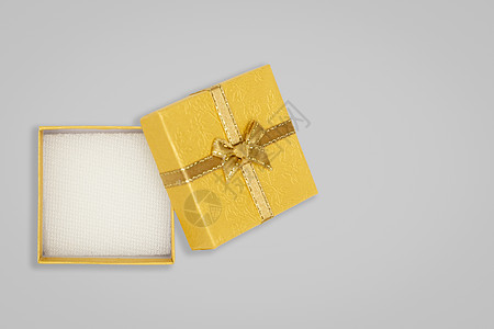 Glay 背景上的打开黄色礼品盒的顶部视图 附有副本图片