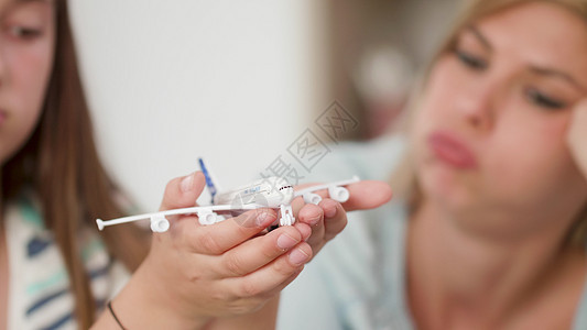 少女在手掌里拿着玩具飞机 给妈妈看旅行高清图片素材