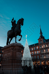马德里 菲利普三世国王的铜像和广场上明亮的圣诞树图片
