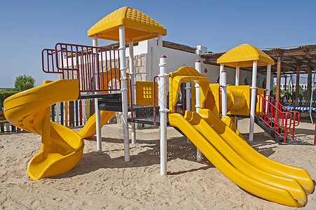 游乐场儿童儿童在热带度假游乐场攀爬框架和滑板 蓝色的 攀爬架背景