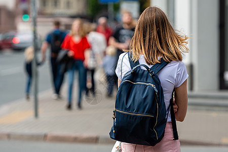 背着背包的年轻女子 在一个分散注意力的街道上 时髦的图片