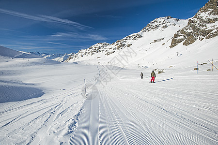 高山滑雪度假胜地的平板滑雪场上的滑雪者 自然图片