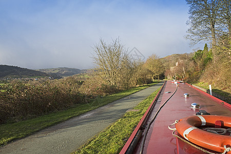 英国运河上的窄船在农村的一条小河上 夏天 树木图片