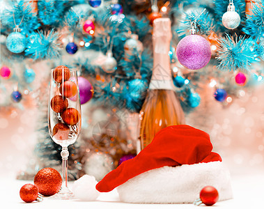 大杯酒杯中的红亮闪光球 在装饰圣诞树的背面上 庆祝节日 庆典图片