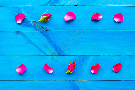 蓝色木制背景上的玫瑰花瓣 纸 婚礼 心 海报背景图片