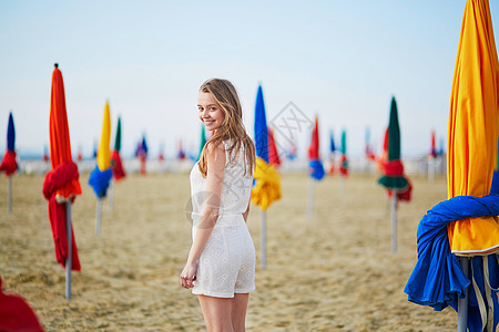 在法国多维尔海滩上 挂着有名的花彩横溢的阳伞的女人 美丽的 阳光图片