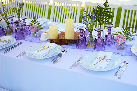 优雅的餐桌布置 用于婚礼订婚复活节晚餐 配有白色陶瓷盘 棉质餐巾和麻线薰衣草花蜡烛 普罗旺斯风格 假期 紫色的图片