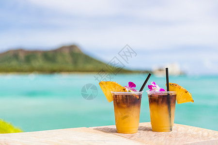 在夏威夷火奴鲁鲁的威基基海滩酒吧旅行度假时享用夏威夷麦泰饮品 夏威夷旅游胜地著名的夏威夷鸡尾酒 享有海洋和钻石头山的美景图片