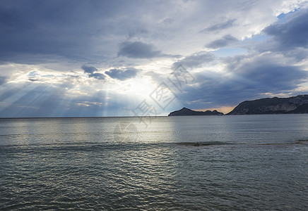 希腊科孚岛日落时 希腊科孚市Corfu 海面和天空 云层剧烈 有太阳光束和观视波尔图铁质湾山丘背景