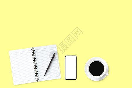 用笔记本 笔 和黄色背景的热咖啡做成的图片