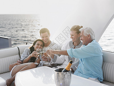 两代家庭在游艇上用香槟庆祝两代人 财富 船图片