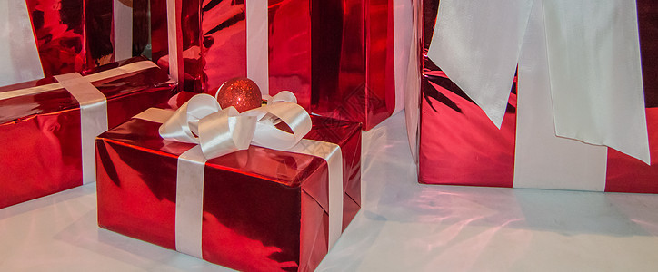 新年横幅 水平背景 白色背景上用白色丝带装饰的红色节日礼盒图片