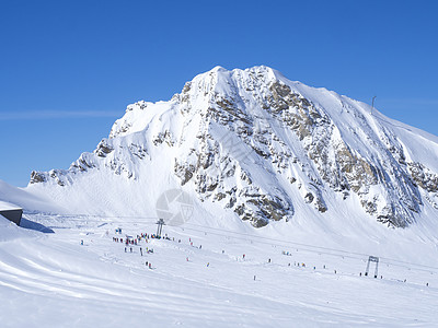 冬季山景与五颜六色的穿着滑雪者在白色的雪坡上 从山顶看蓝天 Kaprun 滑雪胜地 国家公园 奥地利阿尔卑斯山 欧洲图片