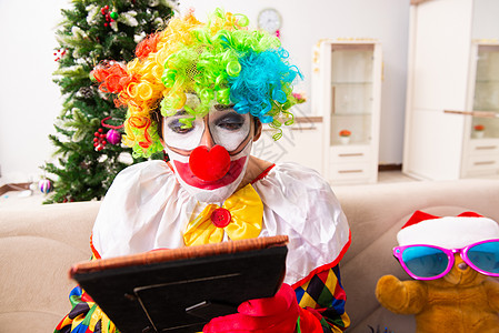 圣诞庆典中搞笑的小丑概念 丑角 家 伤心 艺人图片