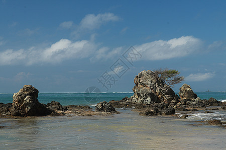 印度尼西亚龙目岛的田园诗般的海滩 Mandalika 海滩多石 许多岩层从水中冒出 库塔海滩上的岩层 完美的一天放松 海岸线 旅图片