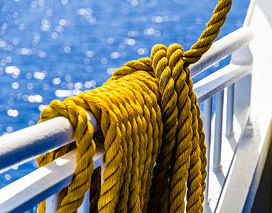 黄纹绳子在一条轮船的栏杆上铺设 闲暇 安全的 水手们背景图片