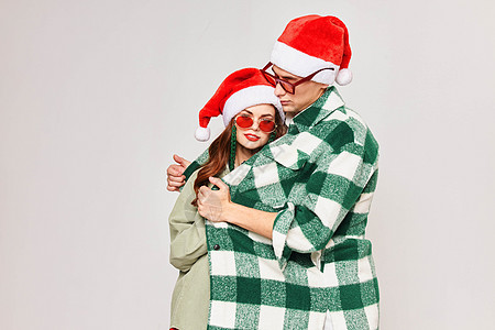 圣诞节麋鹿绿色对夫妇的青色短格衬衫 拥抱节日欢乐背景