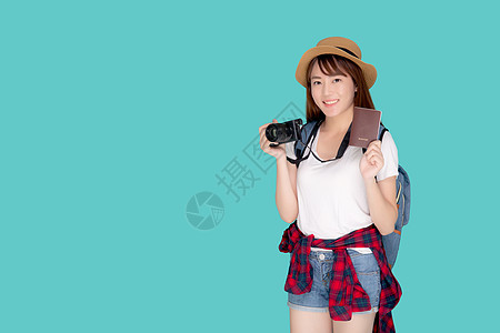 美丽的亚洲年轻女性肖像戴着帽子 微笑着自信地拿着护照和相机 在假期孤立的蓝色背景下带着护照和相机旅行 模范旅游亚洲女孩对旅程感到图片