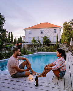 身心放松位于法国阿尔代什省的带木甲板和游泳池的法式度假屋 在法国南部度假屋的豪华假期中 一对夫妇在带木甲板的游泳池旁放松身心 房地产 别背景