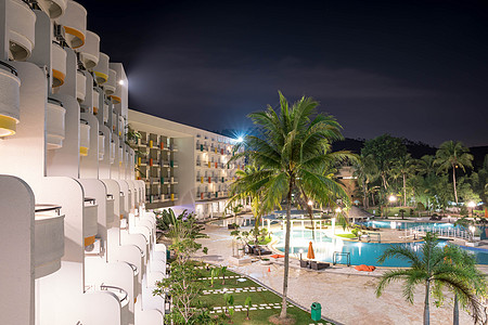 夜间酒店度假胜地的旅馆阳台侧观 有游泳池和灯光照亮 反映蓝色游泳池水长期接触情况图片