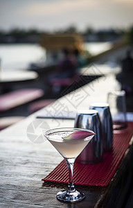茉莉花酒在日落酒吧喝的甘菊和茉莉酒伏特加马提尼鸡尾酒 户外 热带背景