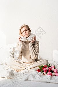 坐在床上的沉睡妇女穿着睡衣 枕头套在脖子上 房间 微笑图片
