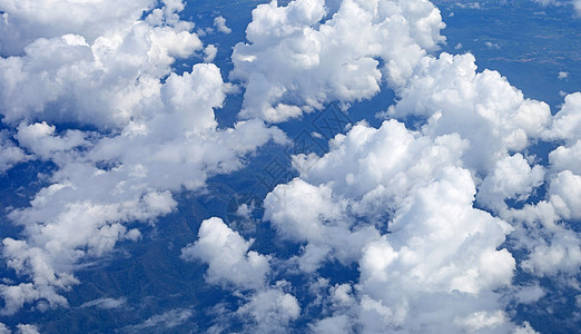 从飞机窗口查看云和陆地的视图 云景 阳光 日落图片