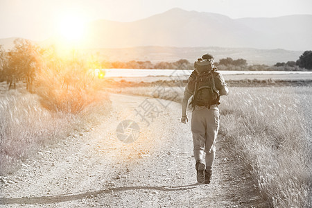 在乡村公路上行走的背背背包青年男子的近视 家庭 浪漫的图片