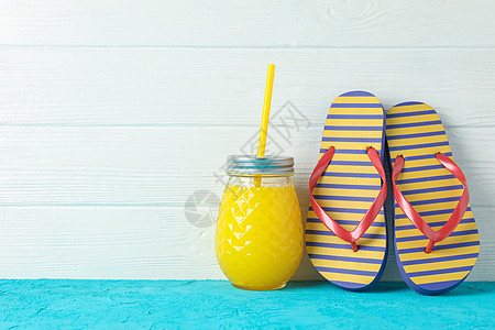 暑假班招生宣传单在白木背景 文字空间的彩色桌子上配有新鲜果汁的翻转浮图和玻璃罐 暑假背景 太阳 橡皮背景