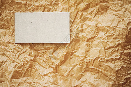 棕色羊皮纸背景上的白色名片平铺 奢侈品牌平铺和品牌标识设计模型 商业 样机图片