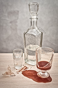 碎玻璃 红番茄汁洒在一瓶伏特加旁边的桌子上 水晶 餐具图片