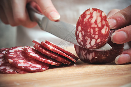 刀把熏香肠切成片 食物 烹饪 产品 蛋白质 猪肉图片
