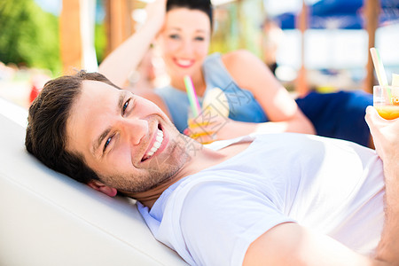 在沙滩酒吧的一对夫妇 喝着饮料放松 快乐的 海滩酒吧背景图片