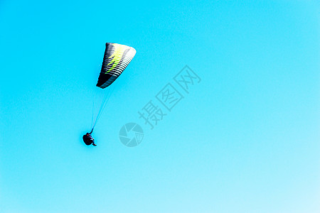 在天空中飞翔的滑翔伞 自由时间花在积极 美妙的经验上 肾上腺素 蓝色的背景图片