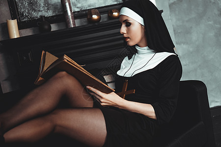 身穿宗教黑西装的美丽的年轻修女持有圣经 宗教概念 虔诚 精神图片