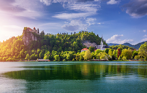 布莱德城堡和圣马丁教堂和布莱德镇令人惊叹的阳光明媚的景色 在湖中倒影 背景是朱利安阿尔卑斯山 布莱德湖 斯洛文尼亚 树 旅游图片