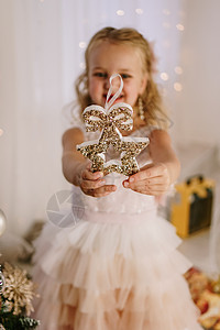 可爱的小可爱女孩 带着圣诞明星 在她的手中微笑在圣诞节的装饰背景图片
