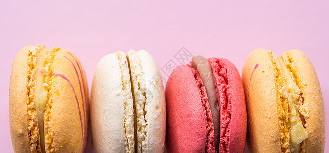 粉红色背景的多彩法国饼干面纱 美味水果 杏仁甜饼 蛋糕面纱 焦糖 奶油图片