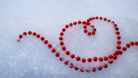 名片设计明亮的红色珠子在新鲜的白雪上形成一颗心的形状 完美的情人节圣诞节新年贺卡背景背景