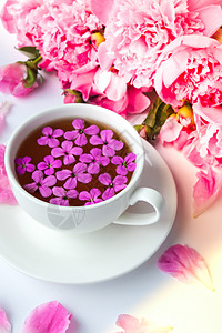明亮的桌子上有粉色牡丹花和一杯茶的创意布局 春季季节性情人节 女人 母亲 3 月 8 日假期 浪漫早餐 时尚博主 问候卡 博客 图片