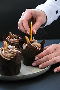 女性亲手制作美味巧克力蛋糕 奶油夹在黑暗背景上 三份巧克力松饼 生日蛋糕晚会的准备 庆祝 假期图片