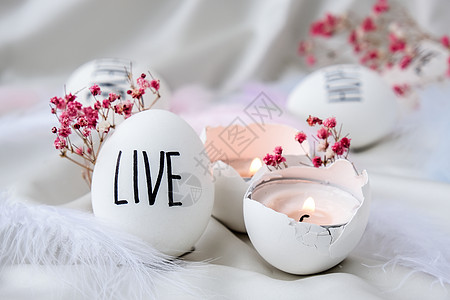 复活节彩蛋组成 复活节消息用笔画的字 桌上贝壳的大角度视图 居住 蛋壳中的蜡烛 烛光 祝贺 字母图片