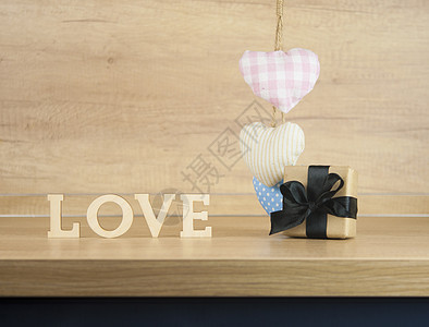 词爱从木制字母与彩色织物心木背景上 情人节快乐哒 礼物盒 丝带图片