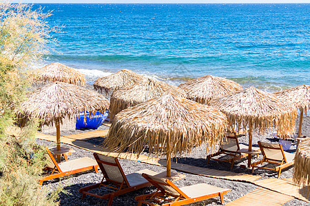圣托里尼海边带雨伞和甲板椅的海滩 海岸线 日光浴床图片