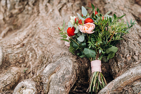 玫瑰鲜花饼婚礼上装饰的花束 上面有玫瑰和胸衣 牡丹 叶子背景
