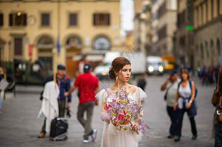 意大利佛罗伦萨的一位新娘穿着婚纱 她手上拿着威尼斯面具 时尚 旅行图片