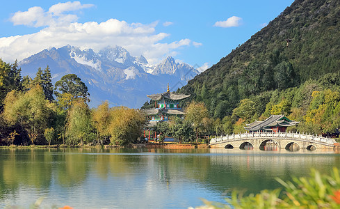中国云南省丽江市玉泉公园黑龙潭上的玉龙雪山和索翠桥 蓝色的图片