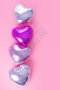 情人节浪漫的设计理念-美丽的真心形箔气球隔离在淡粉色背景 顶视图 平躺 摄影上方 柔和的 平铺图片