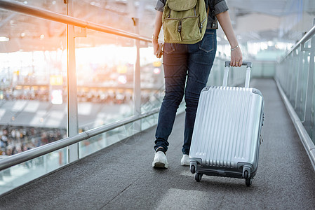 关闭女性旅行者的下半身 带着行李箱乘飞机去世界各地 机场航站楼自动扶梯上的女游客 白色的 步行图片